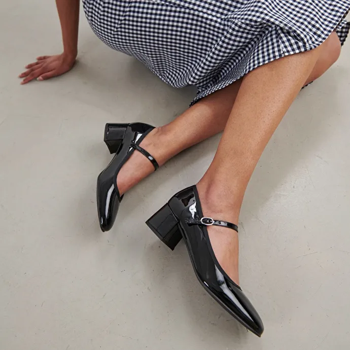 Heeled slippers in black patent leather